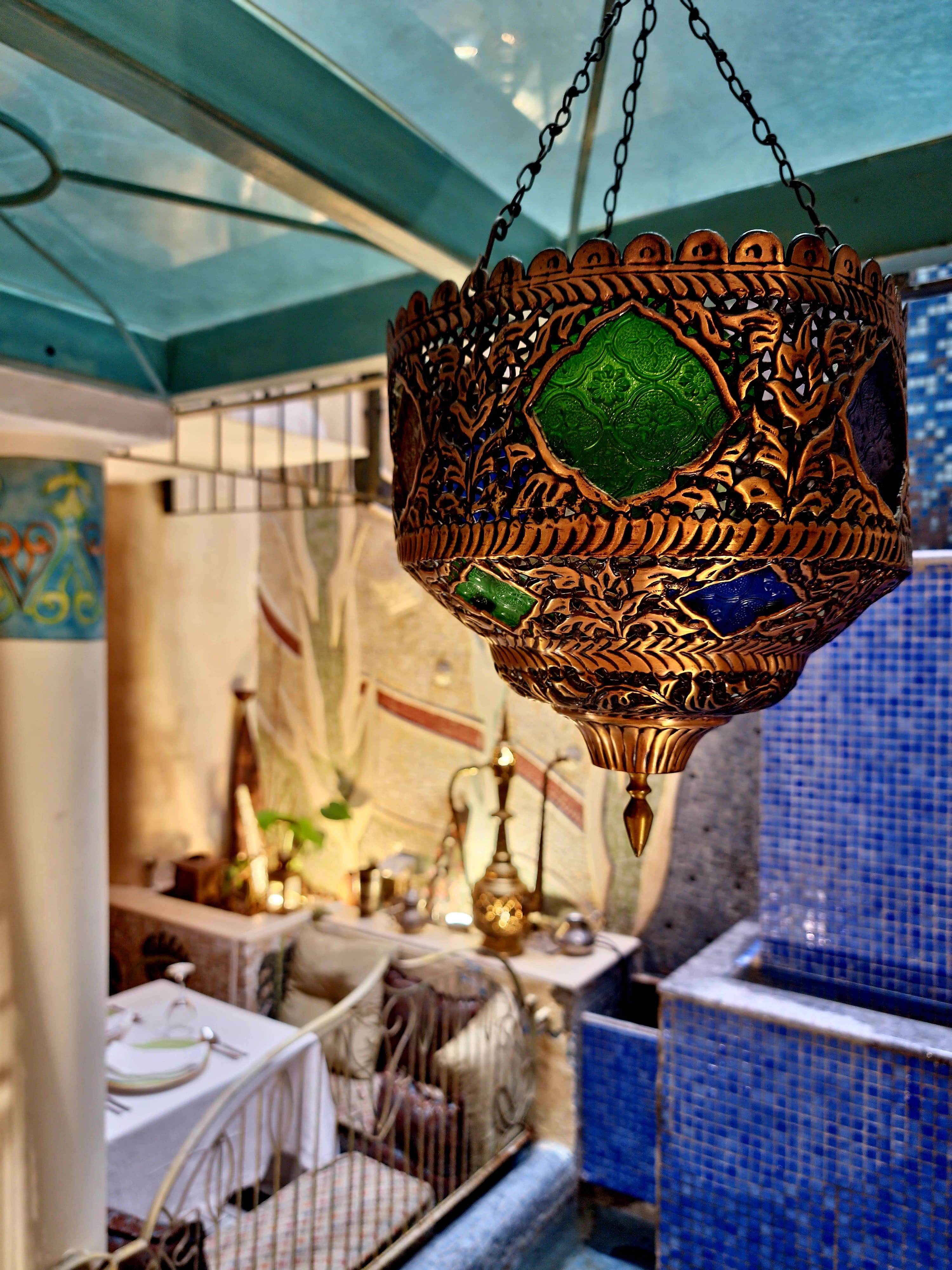 Hanging Moroccan brass lantern with green stained glass