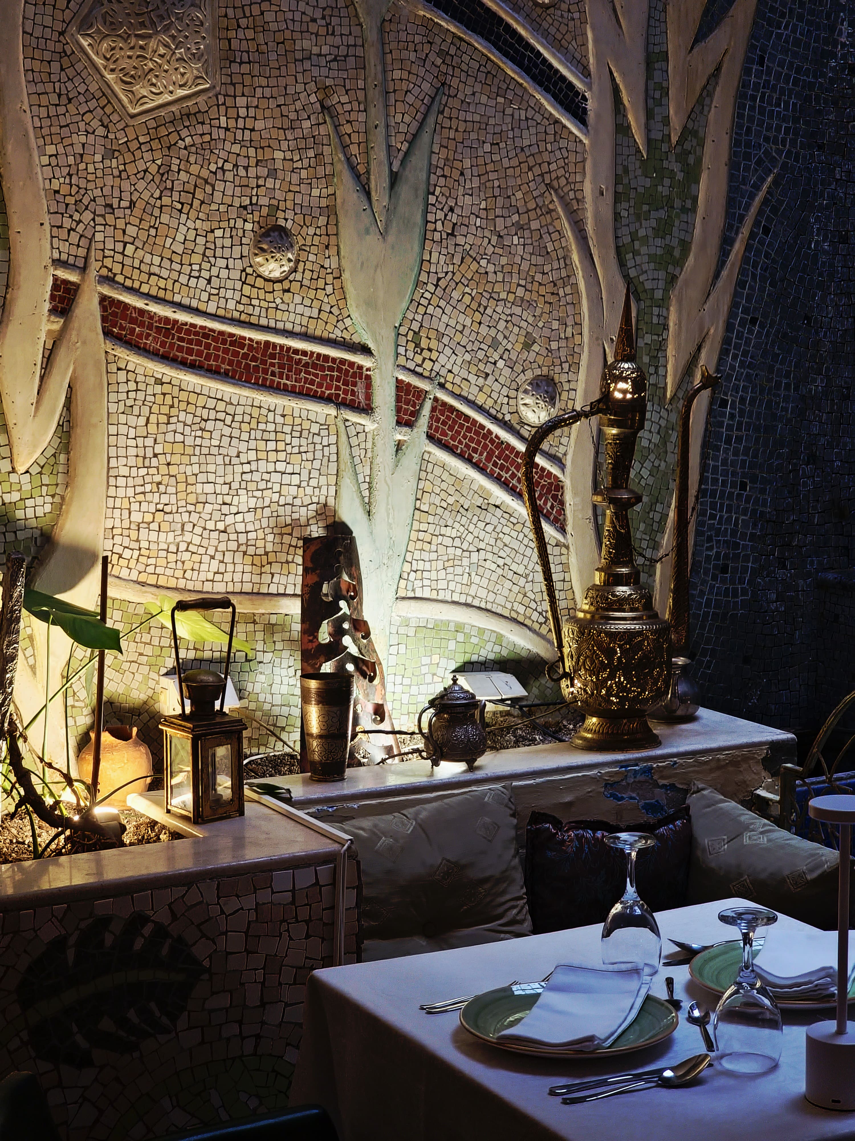 Mosaic wall with brass pitcher and lantern